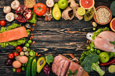 健康的食物背景。健康食品, 鸡肉鱼片, 生肉, 鱼, 鳄梨, 花椰菜, 新鲜蔬菜, 坚果和水果的概念。在木制背景上。顶部视图。复